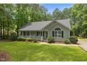Inviting single-story home with a cozy front porch and well-maintained lawn surrounded by mature trees at 296 Gordon Farm Dr, Benson, NC 27504