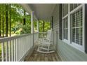 Relaxing front porch with rocking chairs offers a serene spot to enjoy the peaceful surroundings at 296 Gordon Farm Dr, Benson, NC 27504