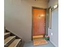 Cozy condo entryway with a welcoming doormat, stairs, and light fixture near the unit number at 3086 Colony Rd # C, Durham, NC 27705