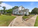 Charming home with a curved walkway, landscaped lawn and welcoming, columned front porch at 309 W Divine St, Dunn, NC 28334