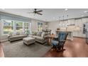 Comfortable living room with hardwood floors, neutral colors, a ceiling fan, and a view into the kitchen at 317 Striped Maple Ct, Apex, NC 27539