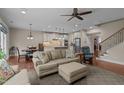 Open living area with hardwood floors, neutral colors, and a view of the staircase and kitchen at 317 Striped Maple Ct, Apex, NC 27539