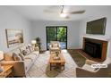 Bright, staged living room featuring a fireplace, ceiling fan, and sliding glass doors to the outdoor deck at 3721 Suffolk St, Durham, NC 27707