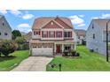 Charming two-story home featuring a stone facade, red shutters and a well-manicured lawn at 40 Horizon Trl, Garner, NC 27529