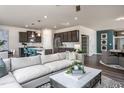 Spacious living room featuring dark cabinets in the kitchen and comfortable seating at 416 Grange Farm Pl, Raleigh, NC 27603