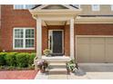 Front door with a covered porch and decorative flower pots at 5028 Blue Jack Oak Dr, Cary, NC 27519
