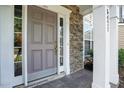 Close-up of a stylish front door framed by stone accents and classic white columns at 5421 Brandy Bay Rd, Raleigh, NC 27613