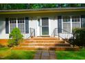 Inviting home entrance with brick steps, black handrails, manicured bushes, and black shutter accents at 622 Enon Rd, Oxford, NC 27565