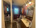Small bathroom with red walls, patterned wallpaper, and a unique mirror at 625 Revell Rd, Selma, NC 27576