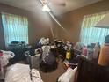 Cluttered bedroom featuring two windows with lace curtains at 625 Revell Rd, Selma, NC 27576