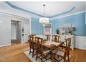 Elegant dining room featuring hardwood floors, a chandelier, and soft blue walls, perfect for gatherings at 6708 Wavcott Dr, Fuquay Varina, NC 27526