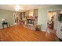 Spacious living room with a brick fireplace, hardwood floors, and built-in shelves at 6717 Valley Dr, Raleigh, NC 27612