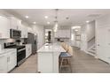Bright, open kitchen featuring white cabinets, stainless steel appliances, and a large island with bar seating at 700 Ben Ledi Ct, Raleigh, NC 27603