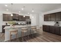 Stylish kitchen featuring a spacious island with bar seating, sleek appliances, and elegant dark wood cabinetry at 712 Ben Ledi Ct, Raleigh, NC 27603