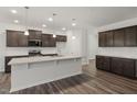 Modern kitchen with a center island, stainless steel appliances, dark cabinets, and a clean, well-lit design at 712 Ben Ledi Ct, Raleigh, NC 27603