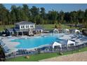 Community pool featuring lounge chairs, cabanas, splash pad and outdoor clubhouse at 713 Traditions Grande Blvd, Wake Forest, NC 27587