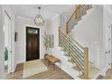 Welcoming foyer featuring a modern staircase, stylish light fixture, and wood flooring at 800 Wilcox St, Raleigh, NC 27607