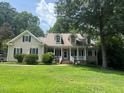 Charming home with a welcoming front porch, lush lawn, and mature trees at 820 Parkridge Dr, Clayton, NC 27527