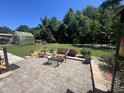 Inviting outdoor patio with ample seating, complemented by a lush green lawn and mature trees for a serene and private backyard oasis at 85 Willard Wood Run, Benson, NC 27504