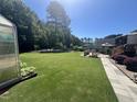 Expansive backyard featuring a well-maintained lawn, mature trees, and a charming patio area for outdoor enjoyment at 85 Willard Wood Run, Benson, NC 27504