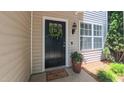 Inviting front entrance featuring a wreath, exterior light and flower pot at 916 Woodside Park Ln, Durham, NC 27704