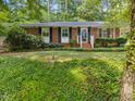 Classic brick home featuring lush landscaping and a welcoming entrance at 926 Wimbleton Dr, Raleigh, NC 27609