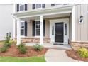 Inviting front porch featuring classic columns, stone accents, and a stylish front door at 94 Black Walnut Dr # 201, Garner, NC 27529
