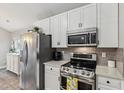 Bright kitchen featuring stainless steel appliances, white cabinetry, and tile backsplash at 10 Oxford Dr, Angier, NC 27501
