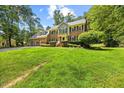 Traditional-style home featuring a spacious front yard, brick facade, and three-car garage at 1005 Enderbury Dr, Raleigh, NC 27614