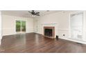 Bright living room features a brick fireplace, wood floors, and access to the back patio at 1006 Mingo Pl, Knightdale, NC 27545