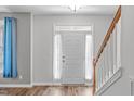 Inviting foyer with staircase and decorative window above a solid white front door at 1111 Barrow Nook Ct, Apex, NC 27502