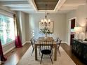 Bright dining room with hardwood floors, modern lighting, and many windows at 1113 Bexley Hills Bend Bnd, Apex, NC 27502