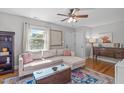 Bright living room with hardwood floors, comfy seating, and natural light from the window at 1209 Edgevale Rd, Durham, NC 27701