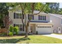 Two-story home with tan siding, black shutters, well-kept lawn, and mature trees at 12320 Tetons Ct, Durham, NC 27703