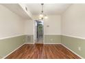 Inviting dining room with two-tone walls, hardwood floors, and a view into the next room at 1302 Springlawn Ct, Raleigh, NC 27609