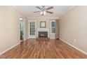 Cozy living room with a fireplace, hardwood floors, ceiling fan and access to the back yard at 1302 Springlawn Ct, Raleigh, NC 27609