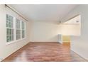 Bright living room boasts hardwood floors and large windows offering ample natural light at 1302 Springlawn Ct, Raleigh, NC 27609