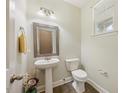 Half bath with a pedestal sink, decorative mirror, and tiled flooring at 132 Ryder Cup Cir, Raleigh, NC 27603
