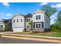 Charming two-story home showcases a two-car garage, gray siding, stone accents and well-maintained lawn at 132 Yellow River Way, Garner, NC 27529