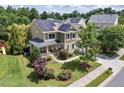 Aerial view of a home with solar panels, a cozy front porch, and a well-maintained yard at 1504 Hemlock Hill Dr, Durham, NC 27703