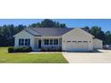 Beautiful single-story home with attached garage and manicured lawn and inviting front porch at 160 Inverness St, Zebulon, NC 27597