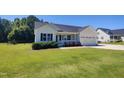 Charming single-story home with manicured lawn, attached garage, and flower-lined porch at 160 Inverness St, Zebulon, NC 27597