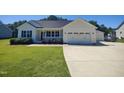 Beautiful single-story home with attached garage and manicured lawn and inviting front porch at 160 Inverness St, Zebulon, NC 27597