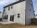 Back exterior featuring a sliding glass door with light gray siding and a small concrete patio at 185 Bourne Dr, Franklinton, NC 27525