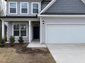 Charming home with a light gray exterior, complemented by a well-maintained front yard and attached garage at 185 Bourne Dr, Franklinton, NC 27525