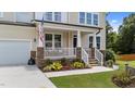 Inviting front porch with stone pillars, white railings, and a view of the landscaped front yard at 185 Twilight Trl, Willow Springs, NC 27592