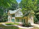 Side exterior view of a two-story brick house with green shutters and a landscaped yard at 2401 Worthing Ct, Wake Forest, NC 27587