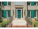 Close-up of the front entrance, featuring a green door, brick steps, and black railing at 2401 Worthing Ct, Wake Forest, NC 27587