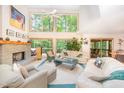 Bright and open living room featuring large windows, a stone fireplace, and comfortable seating at 2612 Scarlet Sage Ct, Raleigh, NC 27613