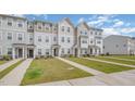 A row of townhomes showcase well-kept lawns and walkways, under a partly cloudy sky at 2708 Chert Ln, Raleigh, NC 27610